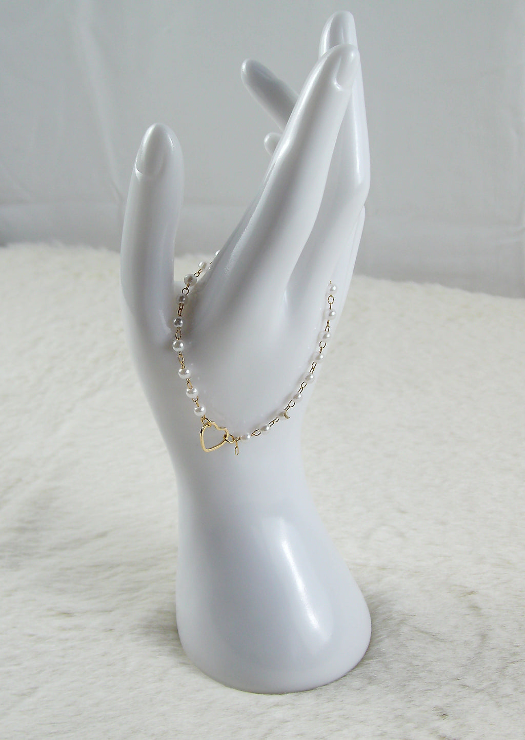 Gouden armband met witte parels en hartje