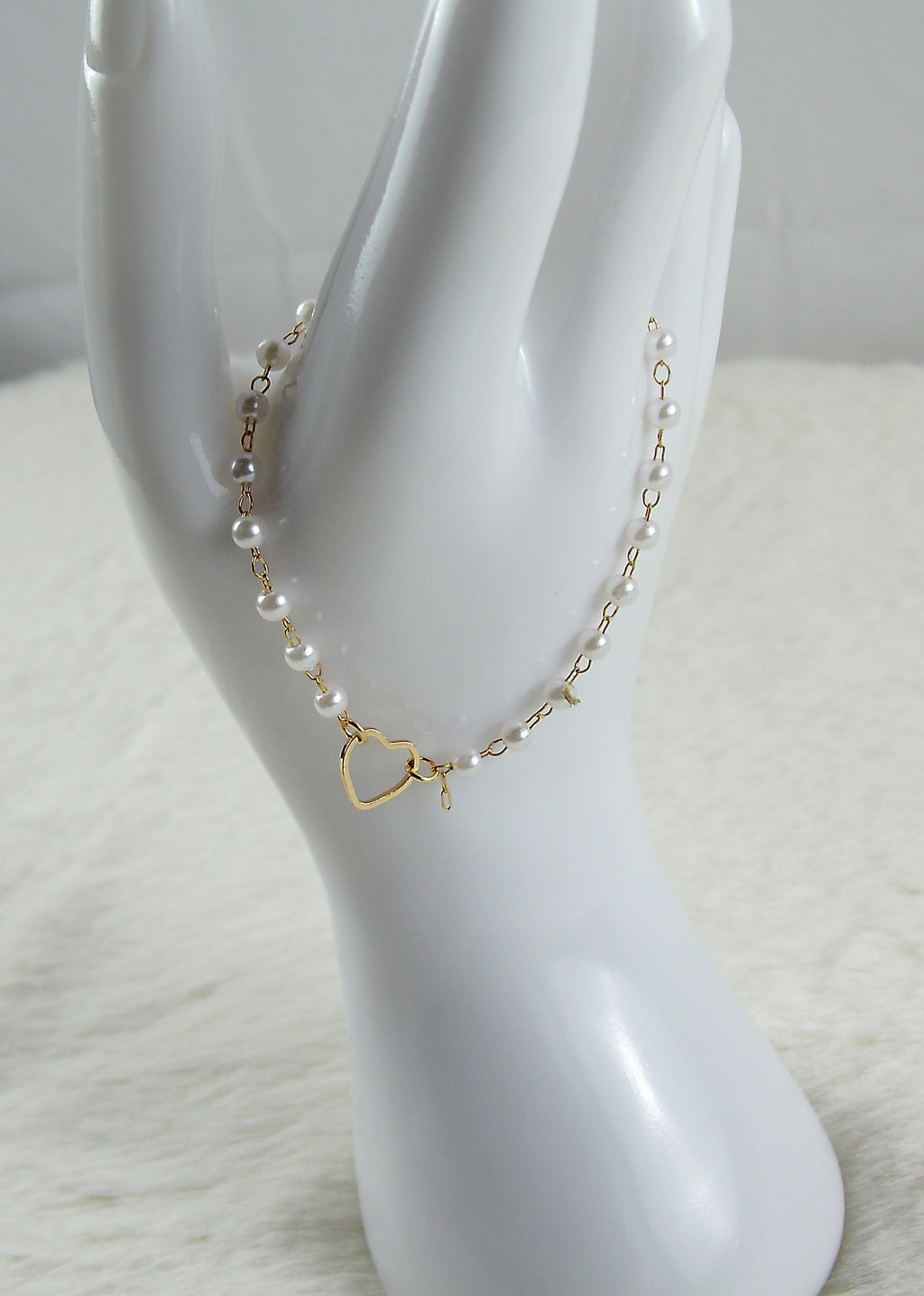 Gouden armband met witte parels en hartje