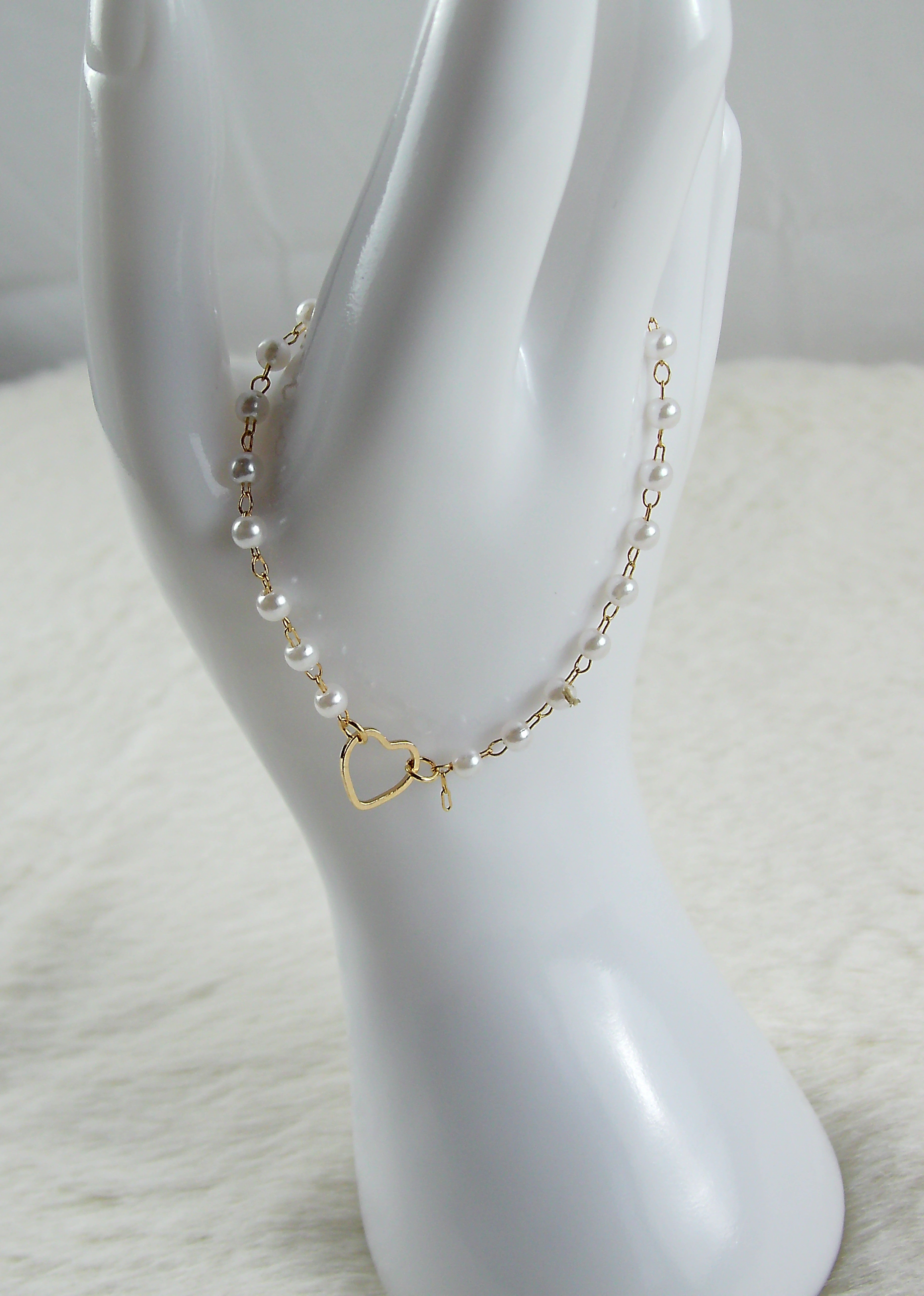 Gouden armband met witte parels en hartje
