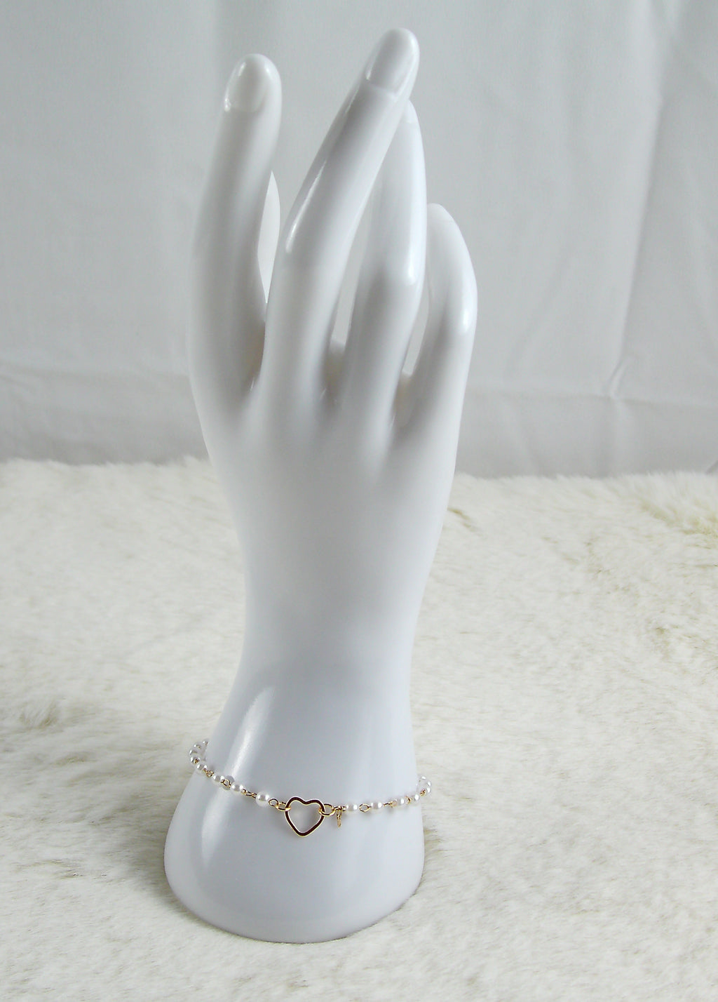 Gouden armband met witte parels en hartje