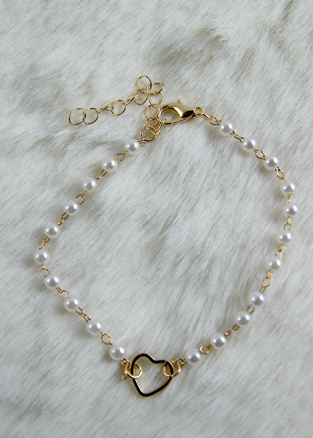Gouden armband met witte parels en hartje