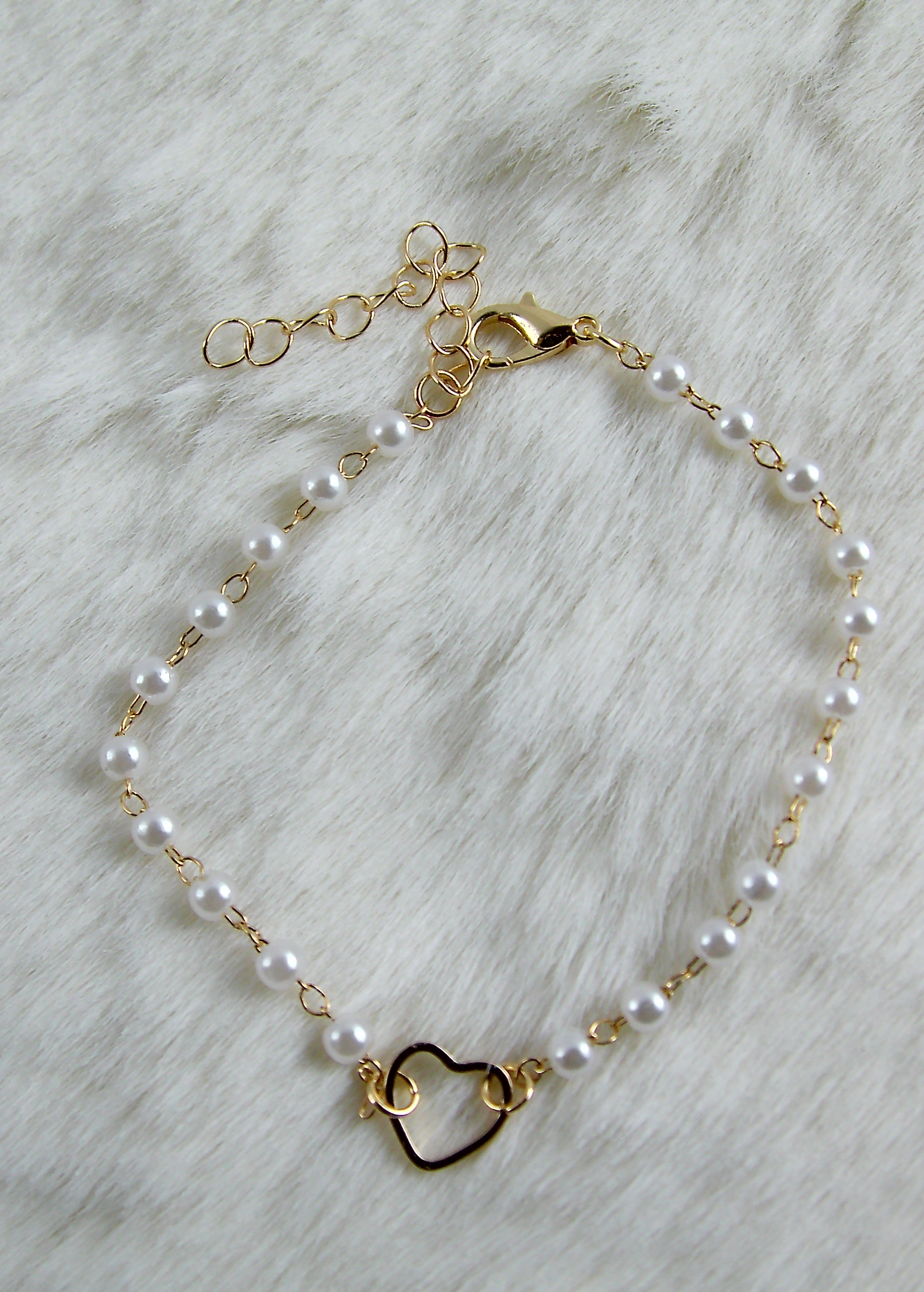 Gouden armband met witte parels en hartje